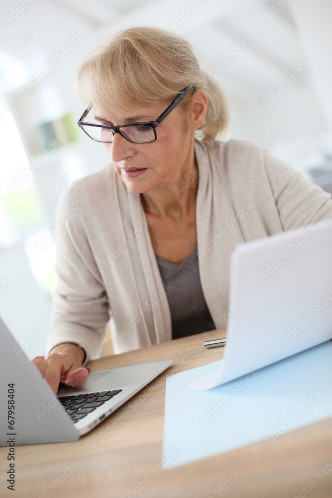 Senior woman filling form online with laptop Senior woman filling form online with laptop