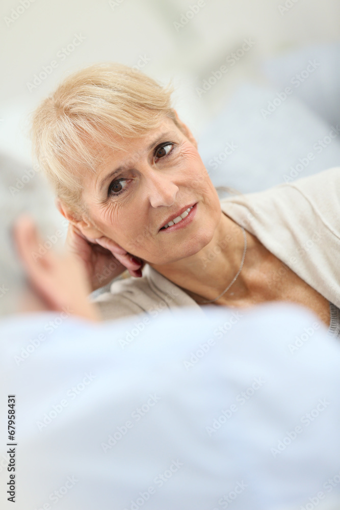 Fototapeta premium Senior couple having a conversation, sitting in sofa