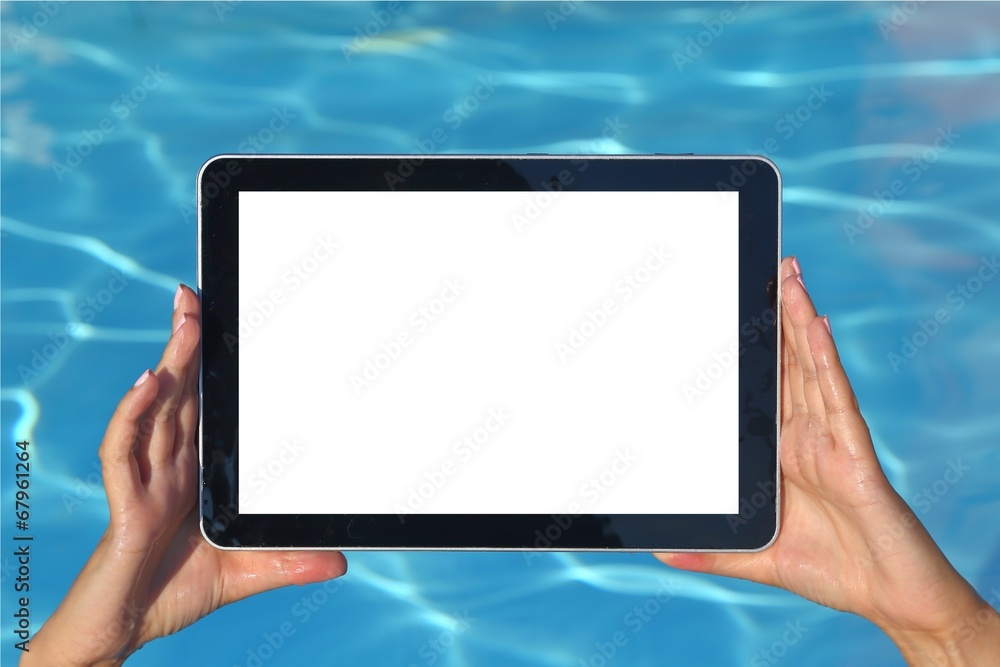 Woman hand holding tablet computer in the pool Woman hand holding tablet computer in the pool