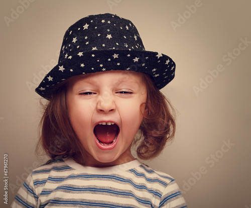 Angry shouting kid girl with open mouth. Vintage portrait