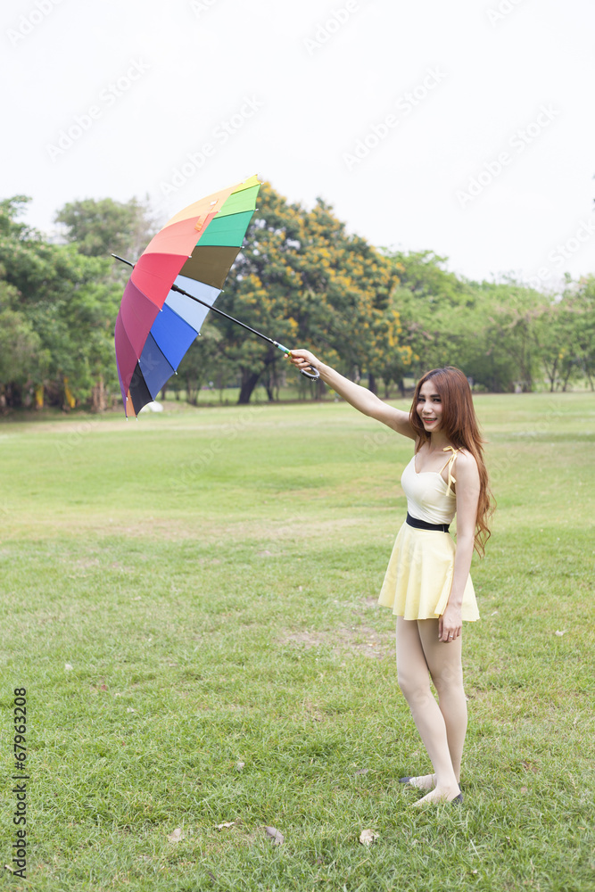 Woman with umbrella standing on the lawn.