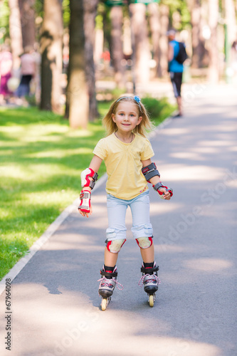 Little girl rollerskating in the park