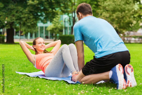 smiling woman doing exercises on mat outdoors © Syda Productions