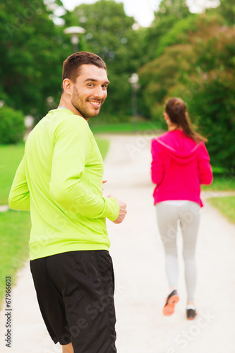 Fototapeta Naklejka Na Ścianę i Meble -  smiling couple running outdoors