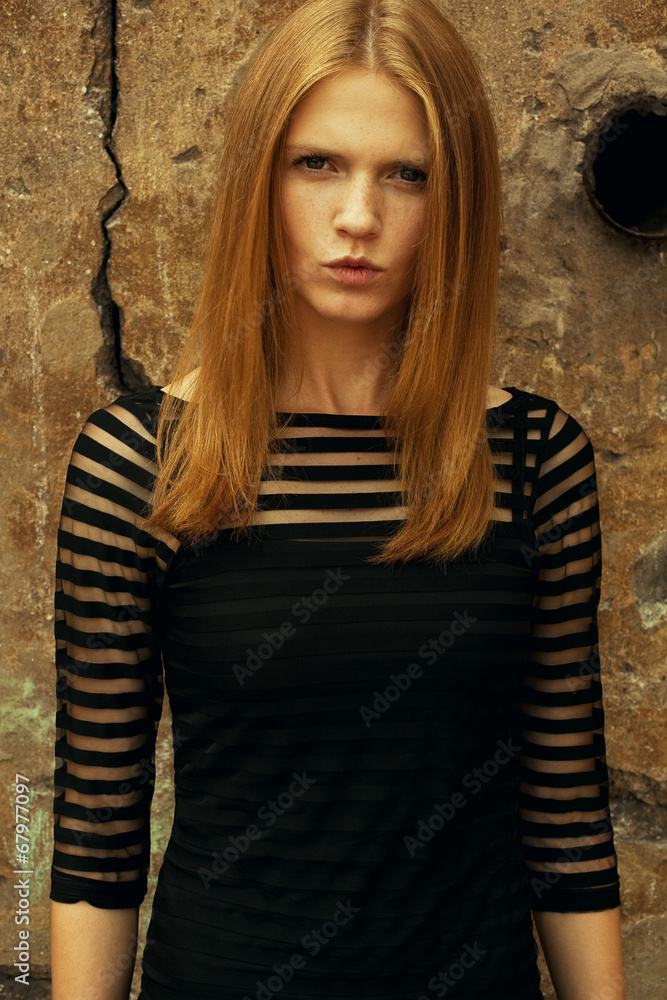 Young beautiful red-haired girl wearing trendy black dress Young beautiful red-haired girl wearing trendy black dress