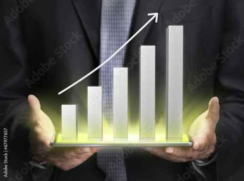 Vászonkép Businessman holding a graph showing growth