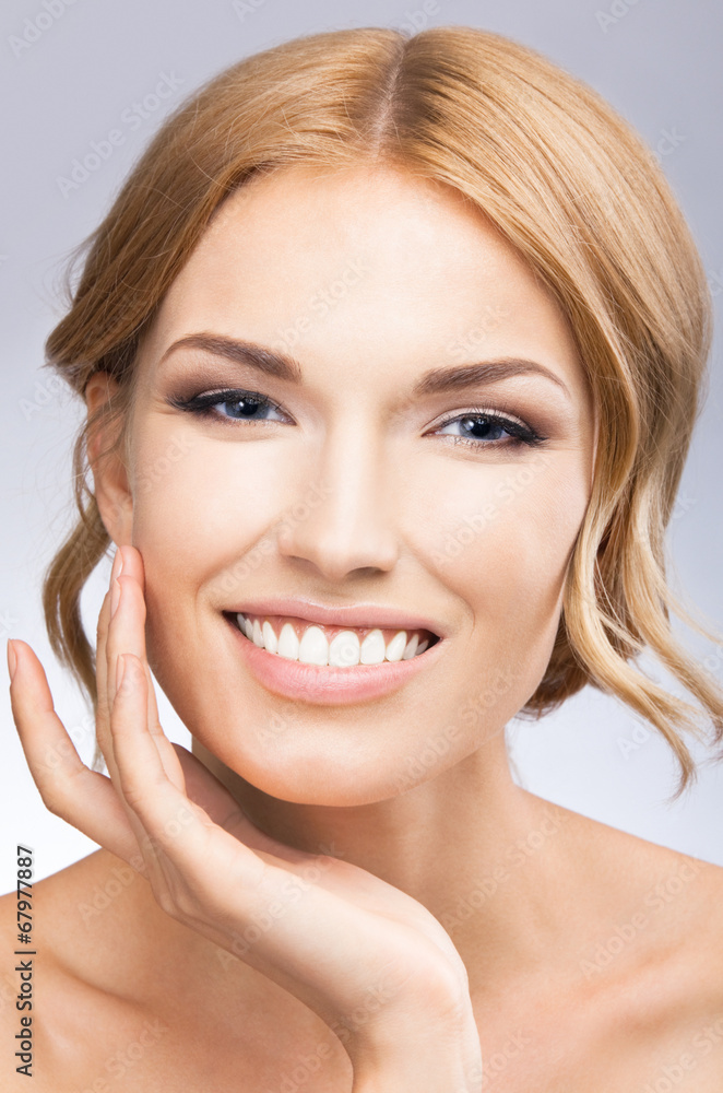 Woman touching skin or applying cream, on grey Woman touching skin or applying cream, on grey