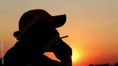 Portrait of a lonely man, smoking a cigarette at sunset.