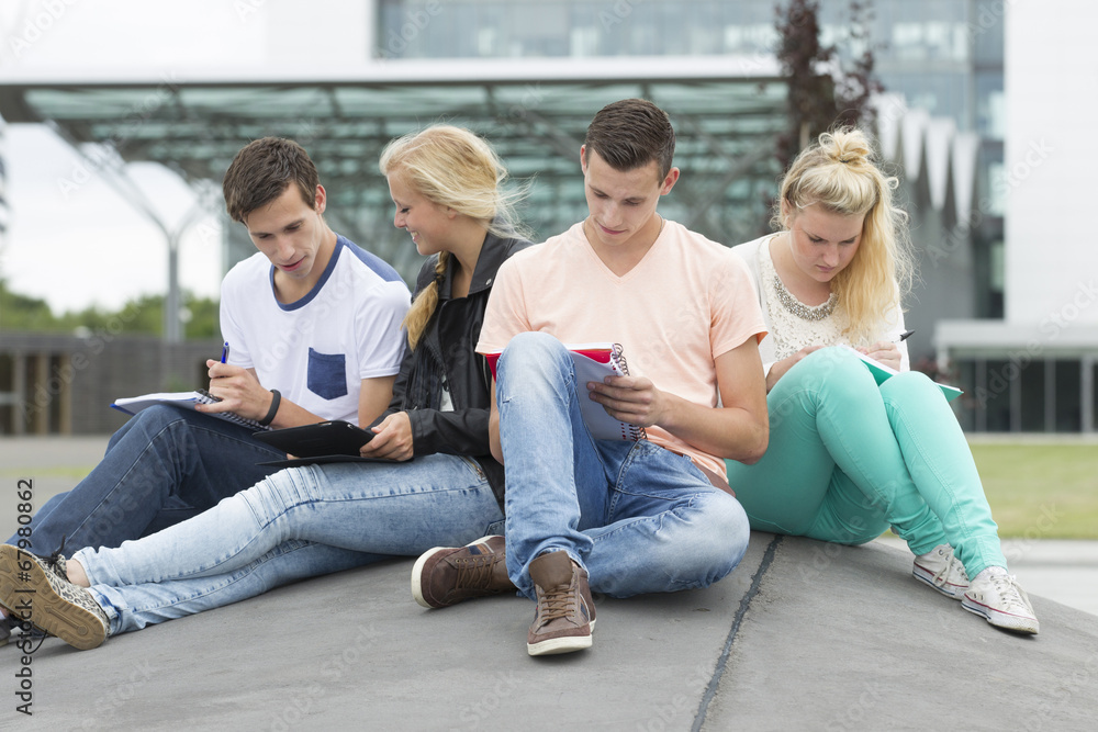 Four students are learning while sitting on the ground Four students are learning while sitting on the ground