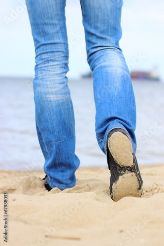 Legs of woman on the beach in summer