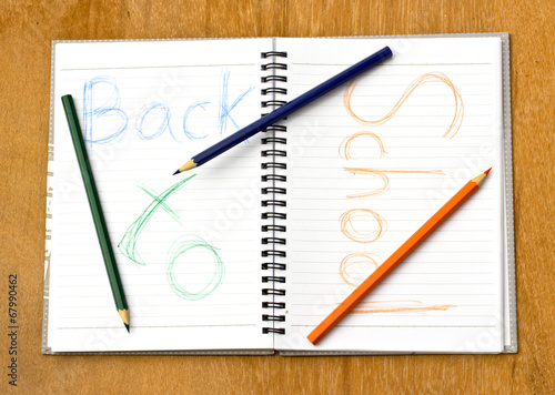 colorful pencil and notebook on wood background.The text back to