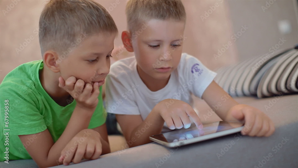 two little boys playing on the tablet computer games two little boys playing on the tablet computer games