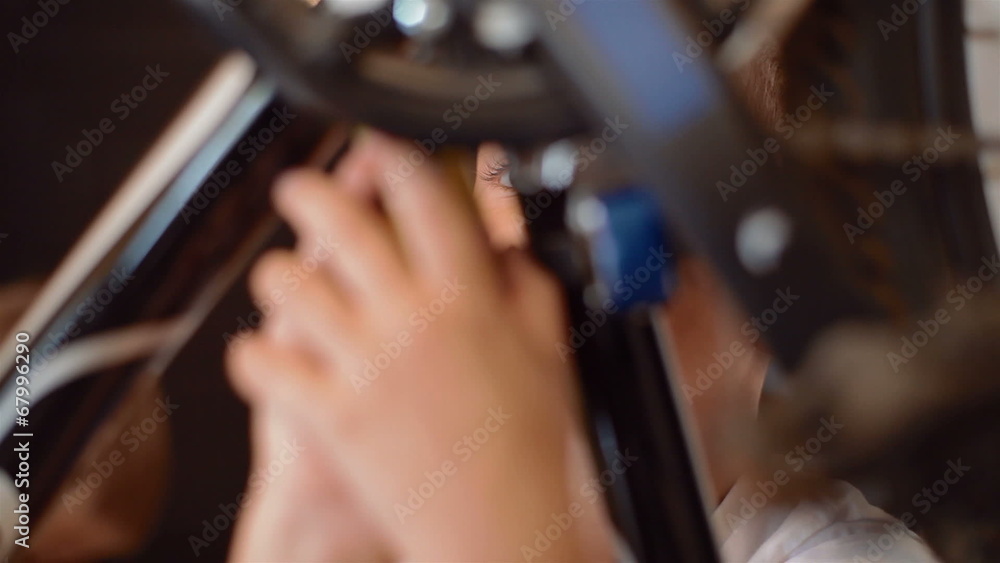 Little boy repairing a bicycle, he tightens the nuts and bolts