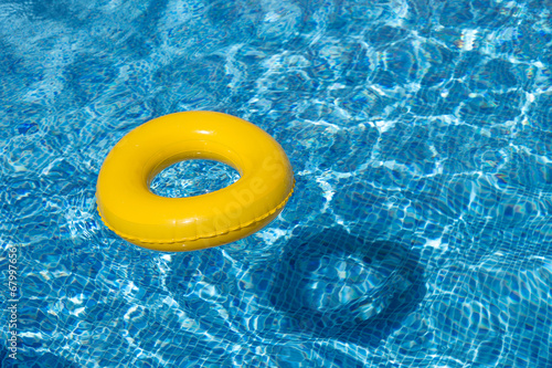 Yellow pool float, pool ring in cool blue refreshing water