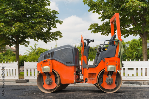 Eine kleine orange Strassenwalze - Tandemwalze mit Knicklenkung photo