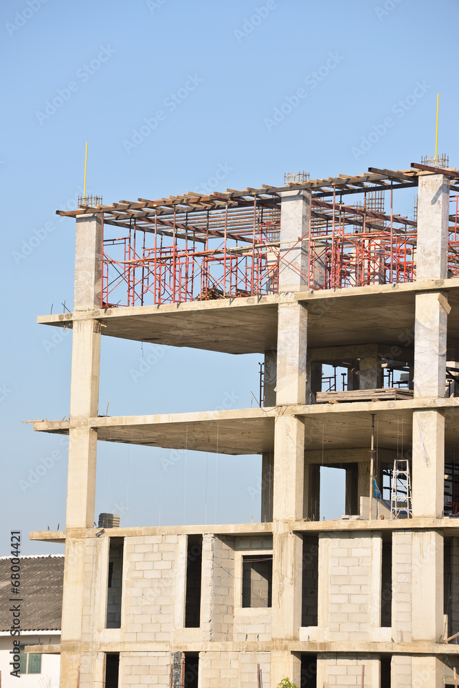Construction site with scaffolding against blue sky Construction site with scaffolding against blue sky