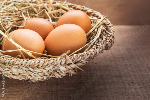 Brown eggs in basket on wooden table