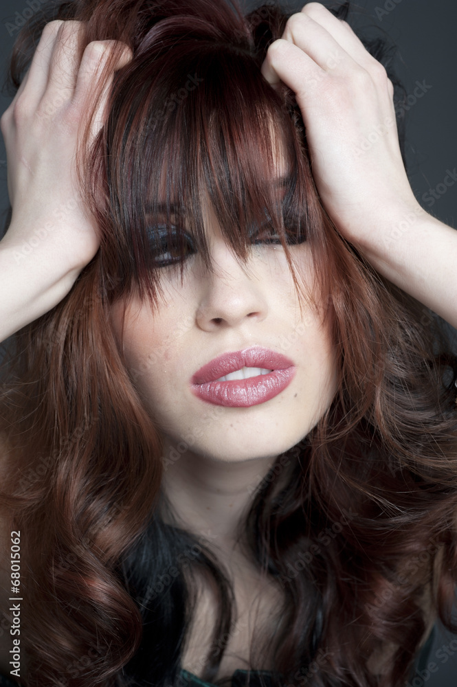A young gorgeous female model poses while playing with her hair. A young gorgeous female model poses while playing with her hair.