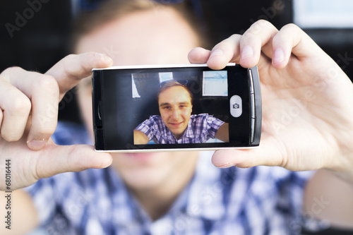 Young fashionable hipster man with sunglasses taking a selfie