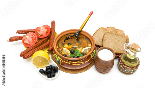 Dish of russian hodgepodge soup in ceramic pot and other foodstu