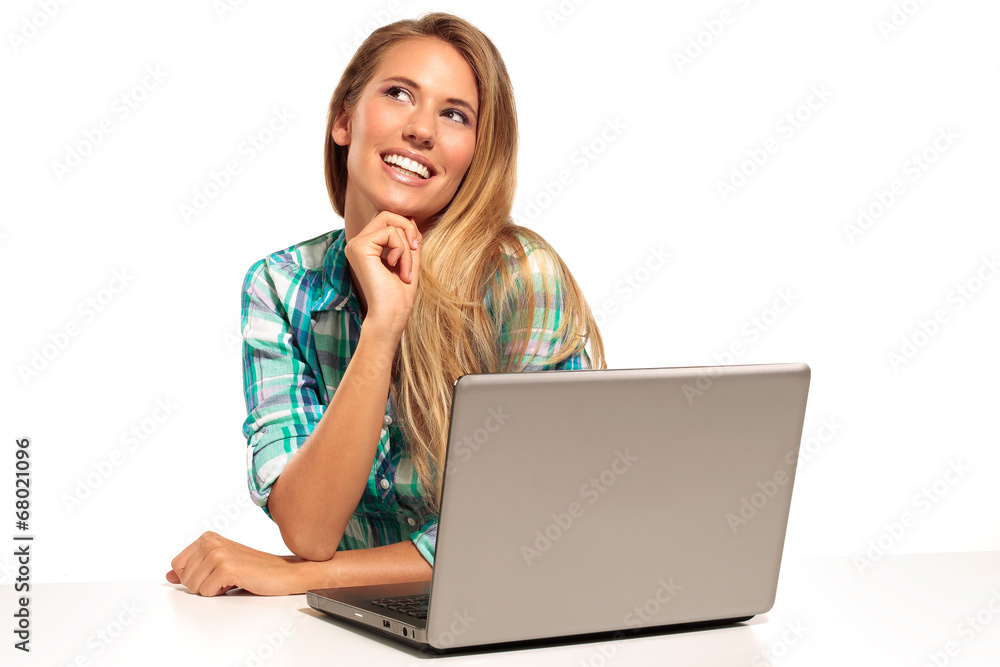 Happy woman using laptop seated at the desk Happy woman using laptop seated at the desk