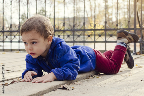 Child laying on ground outside