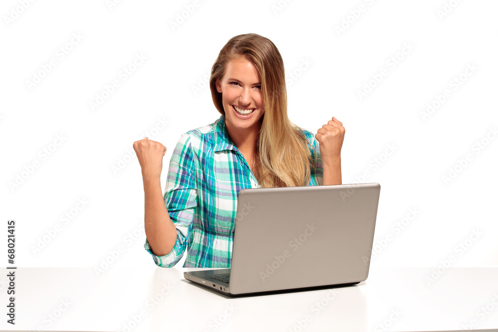 Happy woman using laptop seated at the desk Happy woman using laptop seated at the desk