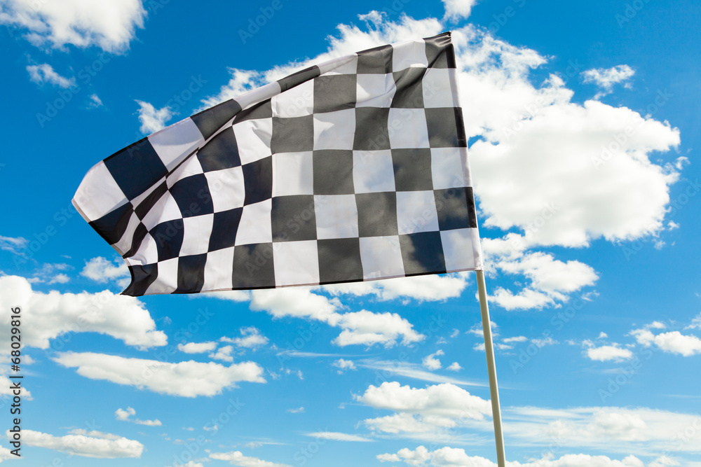 Race flag with blue sky and clouds on background