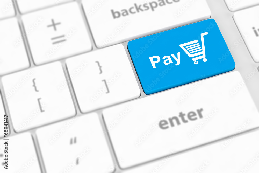 Pay key with shopping cart icon on a white keyboard Pay key with shopping cart icon on a white keyboard