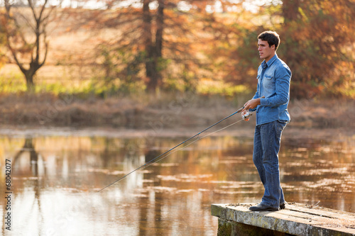 young man fishing by lake
