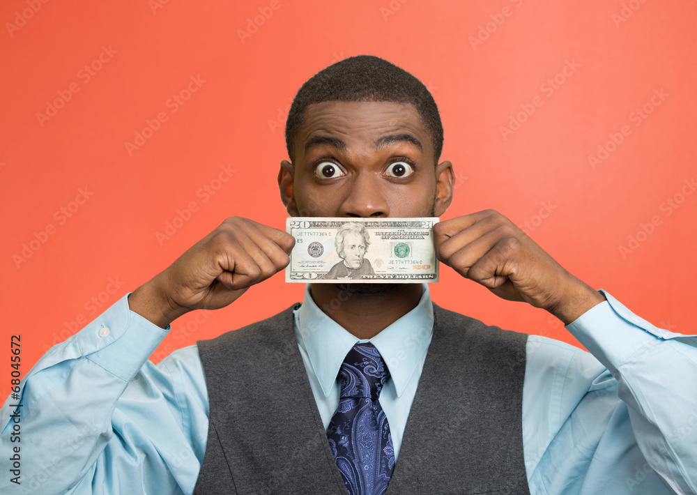 Shocked man with dollar bill covering his mouth red background Shocked man with dollar bill covering his mouth red background