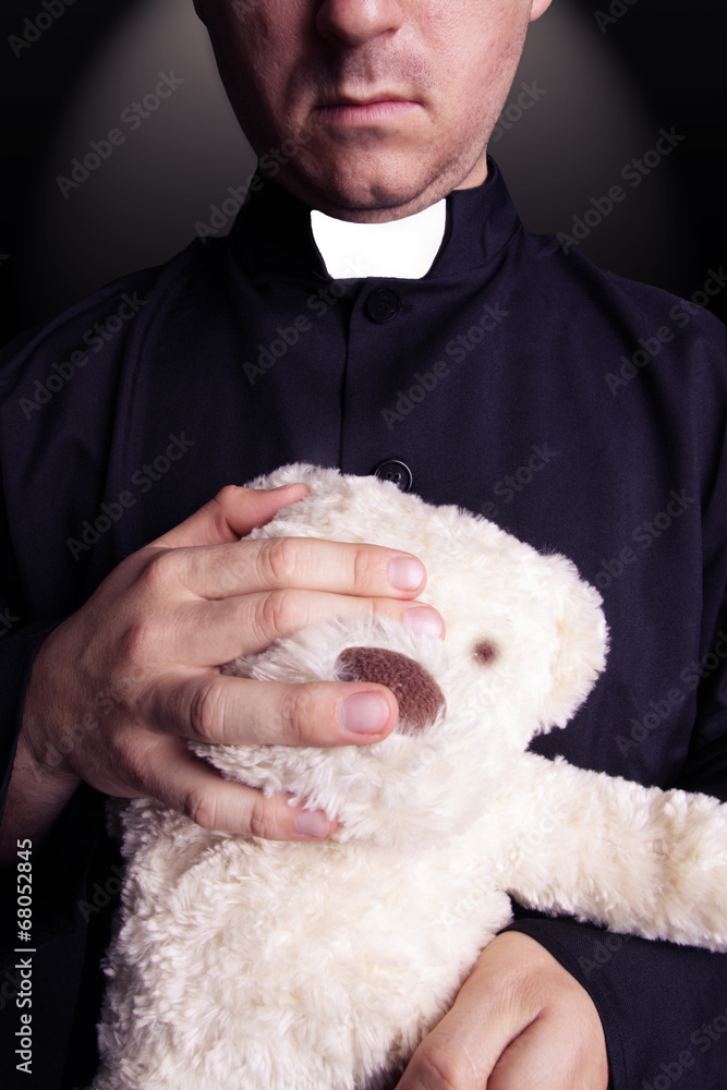 The priest holding a teddy bear The priest holding a teddy bear