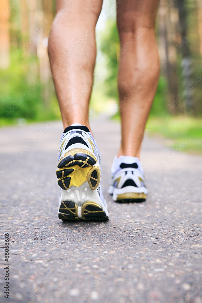 Jogging man. Running shoes and legs of male runner outside on ro Jogging man. Running shoes and legs of male runner outside on ro