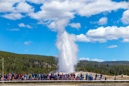 Tourists watching the Old Faithful erupting in Yellowstone Natio