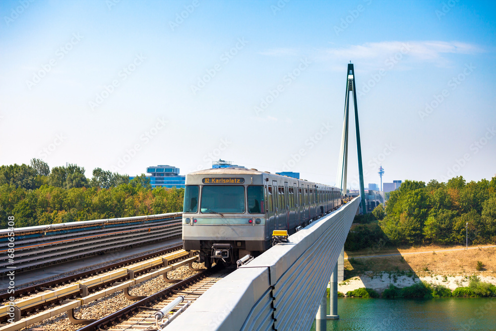 Naklejka premium Vienna metro train passing a bridge over Danube river