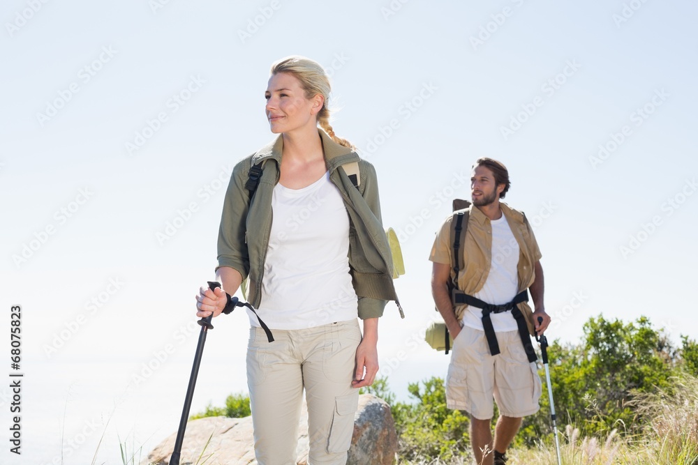 Fototapeta premium Attractvie hiking couple walking on mountain trail