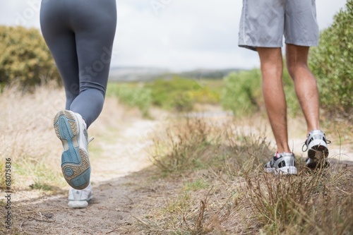 Fit couple jogging on mountain trail