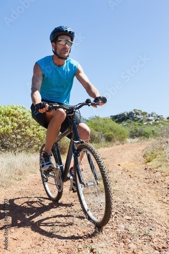 Fototapeta Naklejka Na Ścianę i Meble -  Fit cyclist riding on country trail