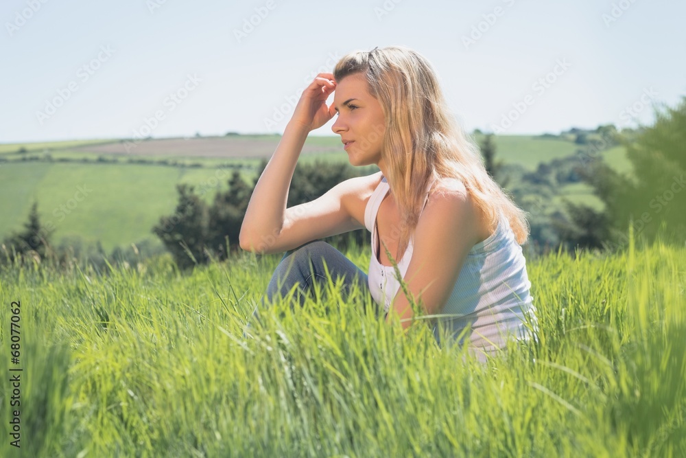 Pretty blonde thinking and sitting on grass Pretty blonde thinking and sitting on grass