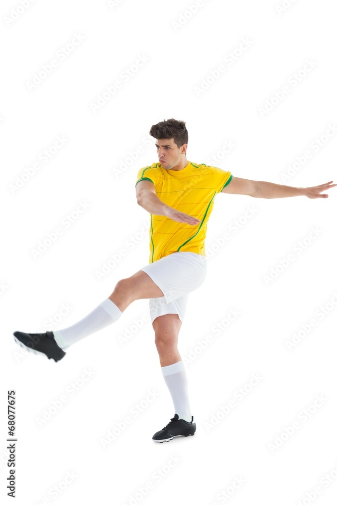 Fototapeta premium Football player in yellow jersey kicking
