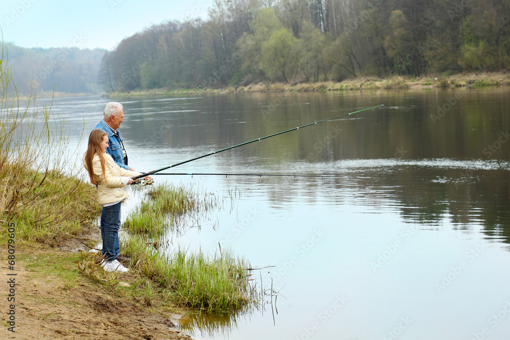 Grandfather and granddaughter are fishing Grandfather and granddaughter are fishing
