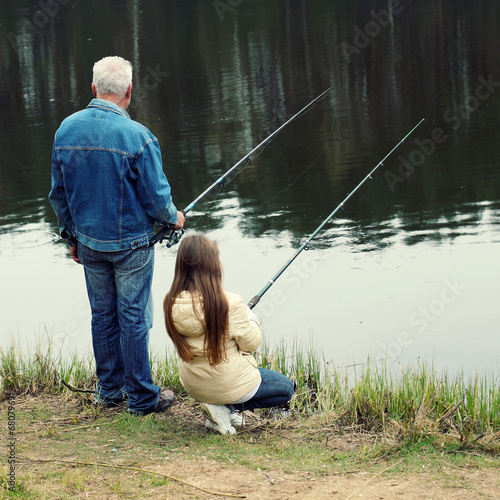 Grandfather and granddaughter are fishing