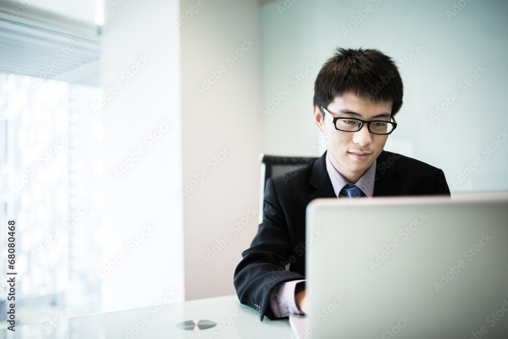 Young handsome man using laptop in his office Young handsome man using laptop in his office