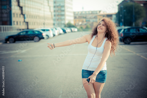 young beautiful long curly hair hipster woman listening music