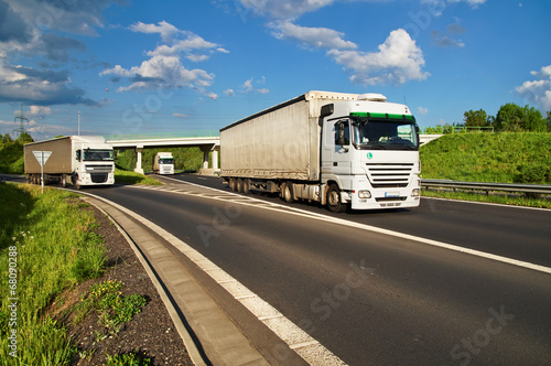 White trucks driving along the highway through the countryside © am