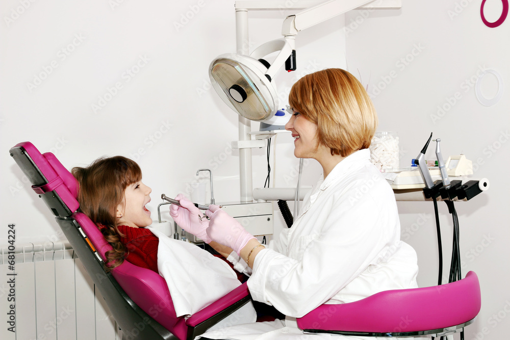 female dentist and little girl patient in dental office female dentist and little girl patient in dental office