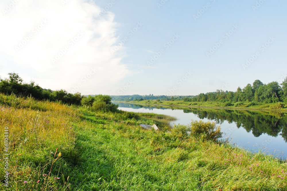 green riverside of small river in summer day,