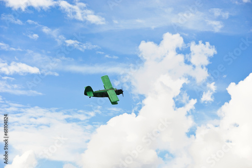 small green plane flying in blue sky photo