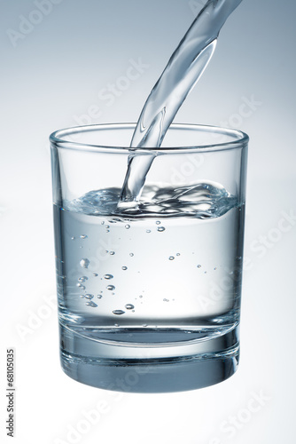 Water is pouring into the glass. With clipping path