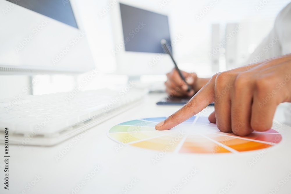Designer working at desk using a colour wheel Designer working at desk using a colour wheel
